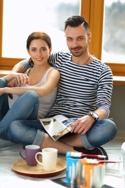 Jurnal seyir ve birbirlerine gülümseyen ev katta oturan çekici çift.