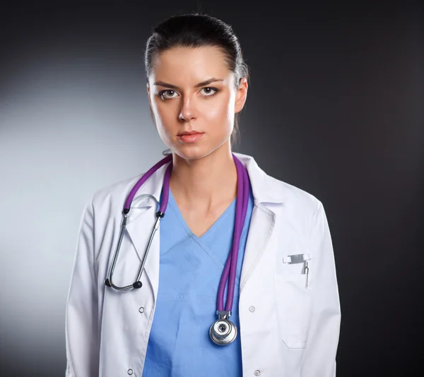 Mujer doctora joven con estetoscopio aislado en gris — Foto de Stock