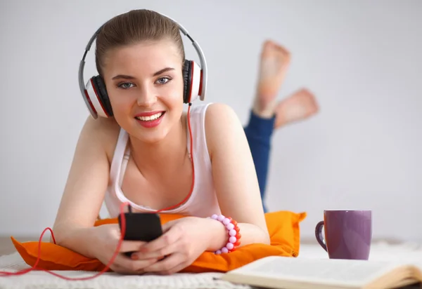 Mujer joven tumbada en el suelo y escuchando música —  Fotos de Stock