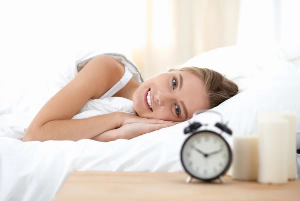 年轻的睡梦中女人和家里卧室的闹钟 — 图库照片