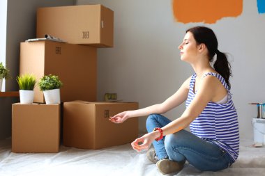 Karton kutuları olan yeni bir evde bir kadın.