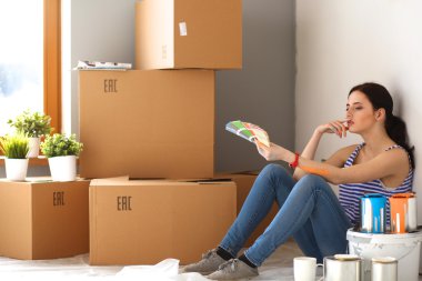 kadın boya renk örneğini yeni ev ahşap yerde oturmak için seçim