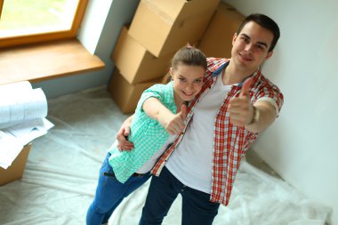 Genç Çift başparmak göstermek yukarıya onların yeni modern tasarım evinde mutlu