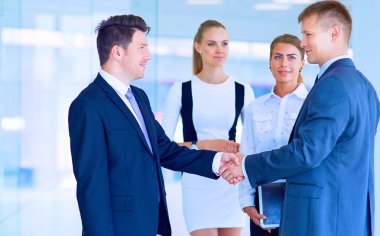 İki başarılı iş adamının el sıkışırken tam boy görüntüsü.