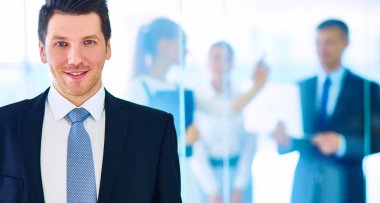 arka planda meslektaşları ile Office genç işadamı portresi