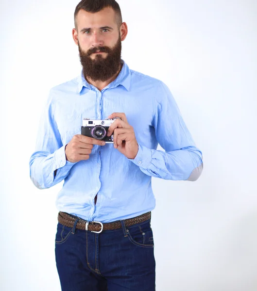 Young beard man holding a camera while standing against white background — Stock Photo, Image