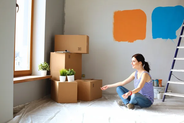 Frau im neuen Zuhause mit Pappkartons — Stockfoto