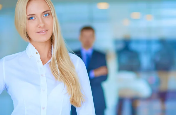 Portret van jonge zakenvrouw in functie met collega 's op de achtergrond — Stockfoto