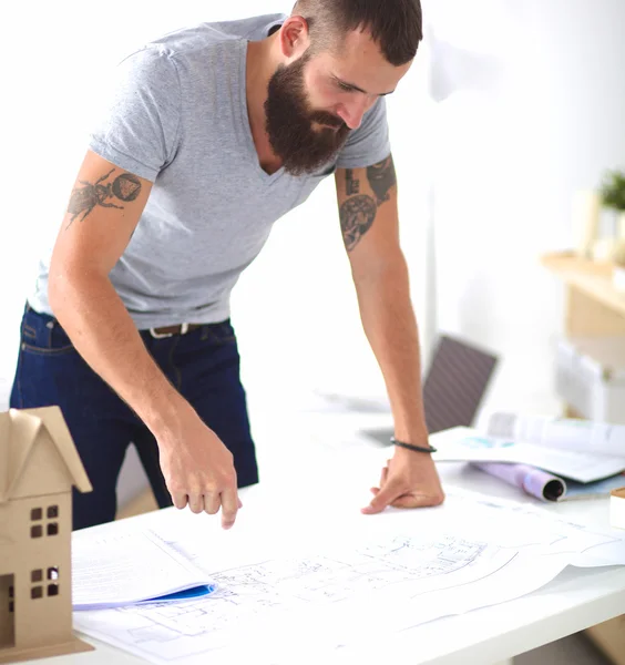 Retrato de diseñador masculino en sombrero con planos en el escritorio —  Fotos de Stock