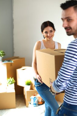 Mutlu genç çift açma veya kutu ambalaj ve yeni evine taşıdıktan