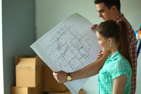 Portrait of young couple moving in new home with plane