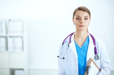 Kadın doktor hastanede dosyayla bekliyor.