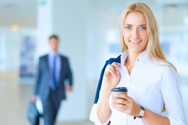 Yound kadın ayakta ofisindeki kahve içmek