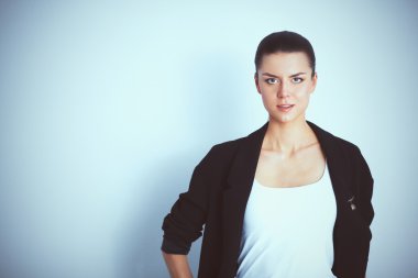 ayakta, gri arka plan üzerinde izole genç kadın