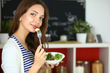 Salata yemek ve karışık salata tutan genç kadın