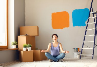 Karton kutuları olan yeni bir evde bir kadın.