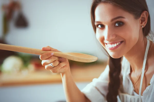 Mujer cocinera en cocina con cuchara de madera —  Fotos de Stock