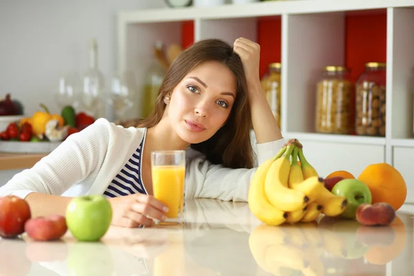 Jeune femme assise près du bureau dans la cuisine — Photo