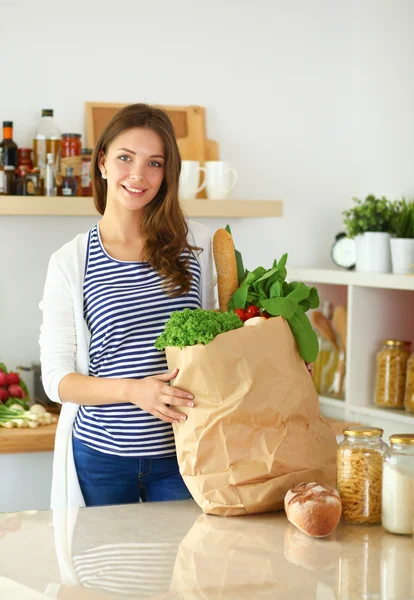 Young woman holding grocery shopping bag with vegetables — Stock Photo, Image