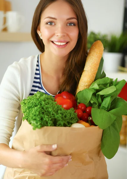 Young woman holding grocery shopping bag with vegetables — Stock Photo, Image