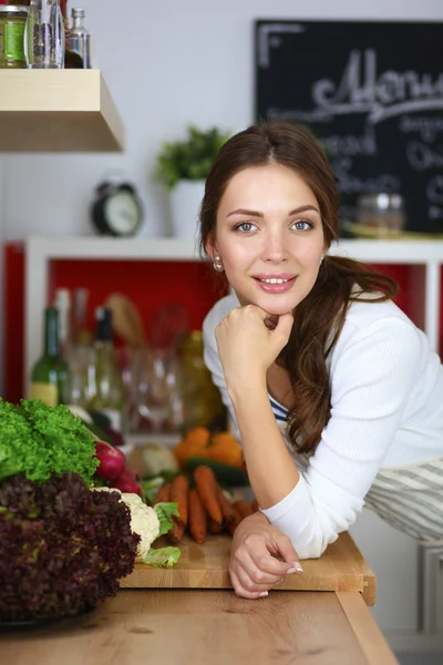 Jonge vrouw in de buurt van bureau in de keuken — Stockfoto