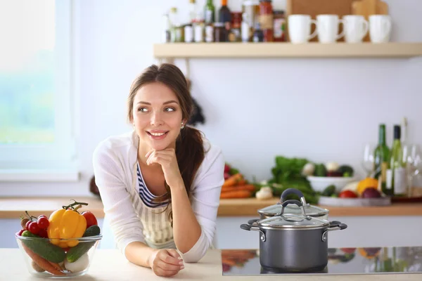 Jonge vrouw in de buurt van bureau in de keuken — Stockfoto