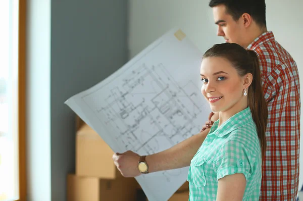 Portret van een jong koppel bewegen in nieuwe huis met vliegtuig — Stockfoto