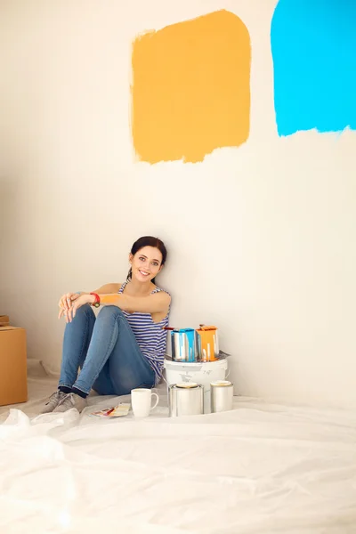 Femme choisissant la couleur de peinture de swatch pour la nouvelle maison assise sur le sol en bois — Photo