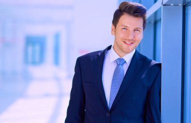 Ofisteki pencerenin yanında duran işadamının portresi