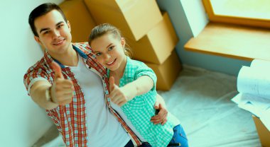 Genç Çift başparmak göstermek yukarıya onların yeni modern tasarım evinde mutlu