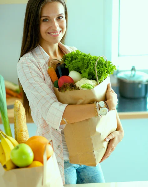 Young woman holding grocery shopping bag with vegetables — Stock Photo, Image