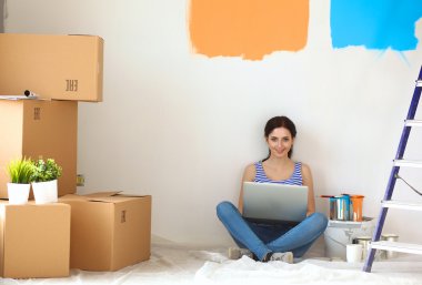 Yeni daire dizüstü bilgisayar ile oturup, boyama sırasında genç kadın portre