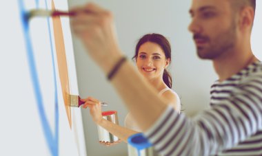 Mutlu gülümseyen genç çift boya iç cephe yeni evin portresi