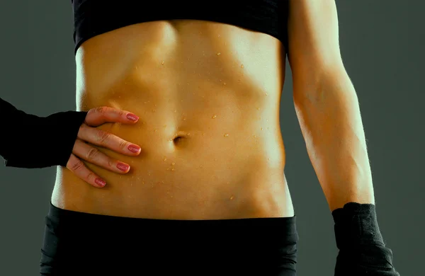 Muscolare giovane donna in piedi su sfondo grigio — Foto Stock