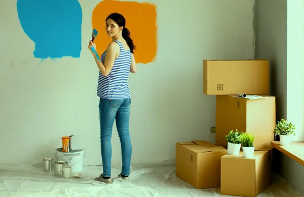 Heureuse femme souriante peinture mur intérieur de la nouvelle maison — Photo