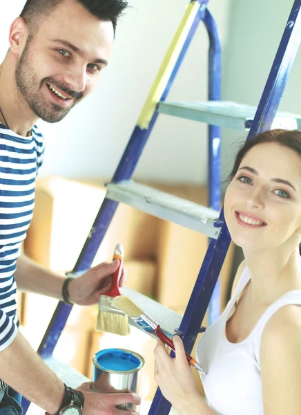 Heureuse femme souriante peinture mur intérieur de la nouvelle maison — Photo