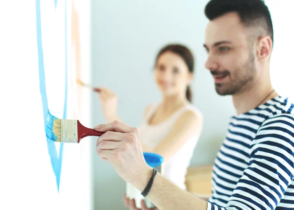 Portret van gelukkig interieur wand via lachende jong koppel-schilderij van nieuwe huis — Stockfoto