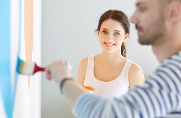 Retrato de feliz joven pareja sonriente pintando la pared interior de la nueva casa —  Fotos de Stock