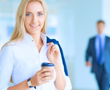 Yound kadın ayakta ofisindeki kahve içmek