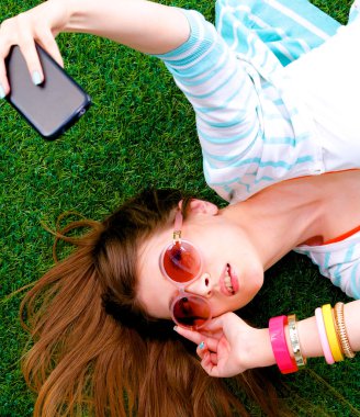 güzel ve genç birbayan yeşil çim yalan onu telefonla selfie yapma