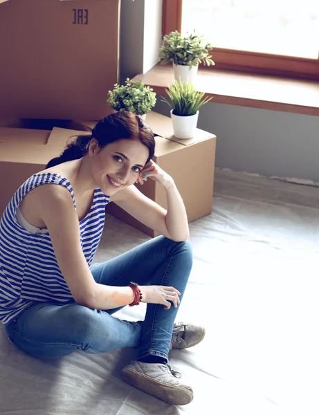 Mujer en un nuevo hogar con cajas de cartón — Foto de Stock