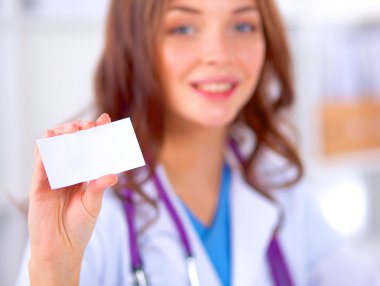 Kadın doktor elinde boş bir kart tutuyor, beyaz arka planda izole edilmiş.