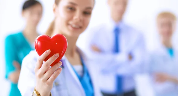 Female doctor with stethoscope holding heart — Stock Photo, Image