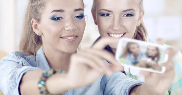 Dos chicas tomando fotos por teléfono en casa — Foto de Stock