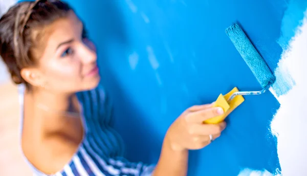 Szczęśliwa piękna młoda kobieta maluje ściany — Zdjęcie stockowe