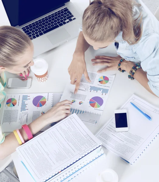 Dos mujeres trabajando juntas en la oficina, sentadas en el escritorio — Foto de Stock