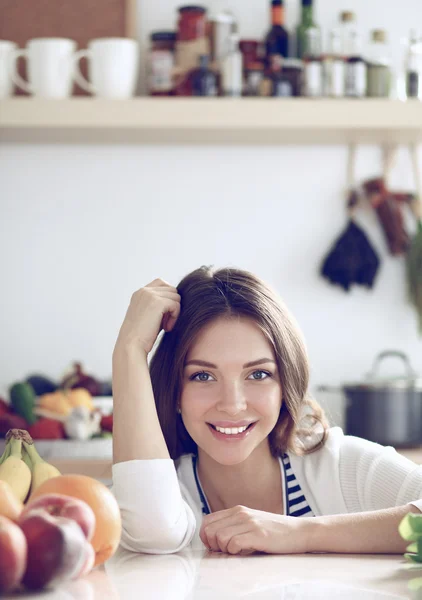 Jonge vrouw in de buurt van bureau in de keuken — Stockfoto