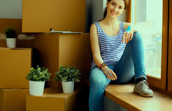 Девушка, сидящая на подоконнике в новом доме — стоковое фото