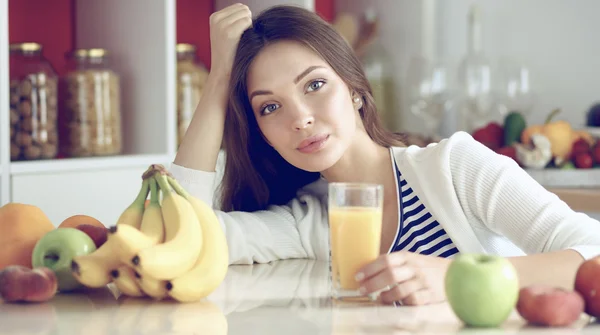 Young woman sitting near desk in the kitchen — Stock Photo, Image