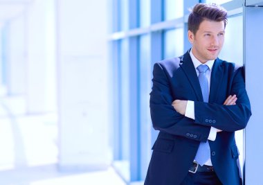 Ofisteki pencerenin yanında duran işadamının portresi